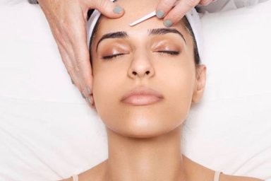 woman dermaplaning face