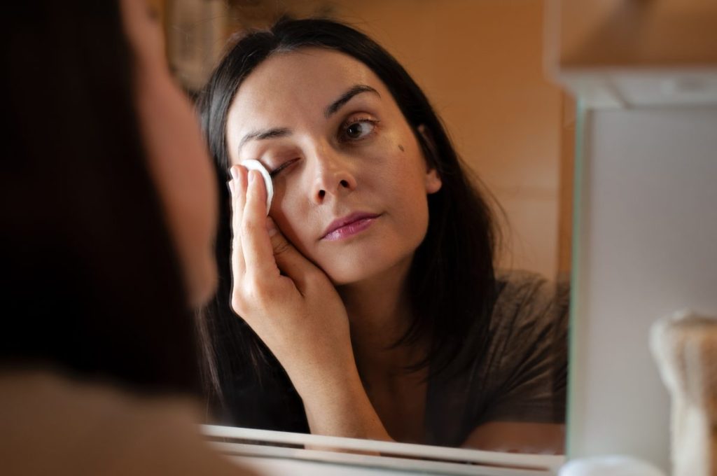 Girl removing makeup as part of night skincare routine